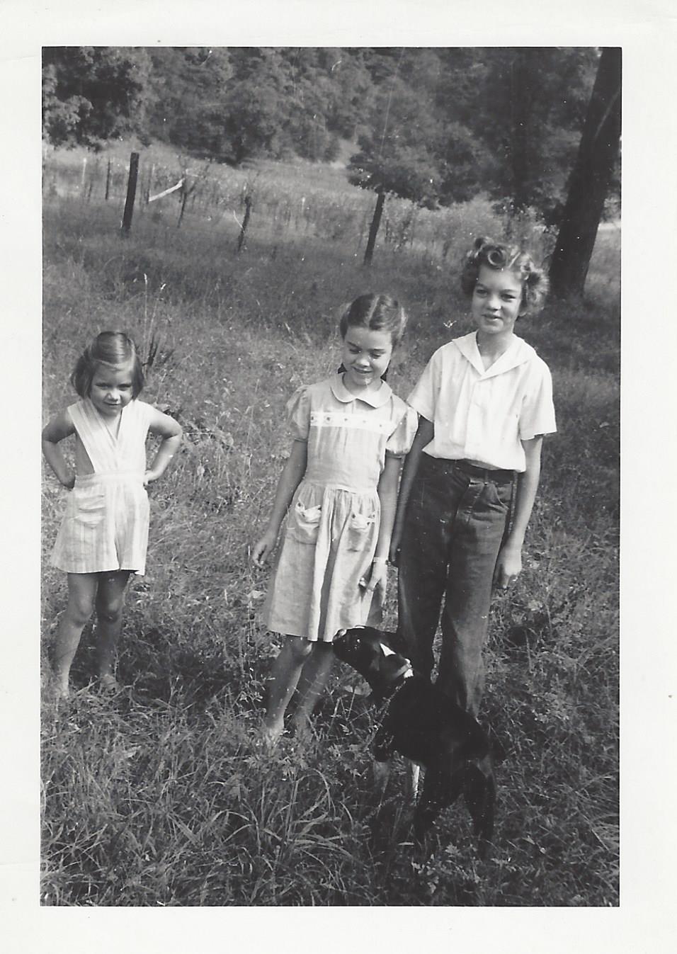 Three Hickman sisters in a field with dog