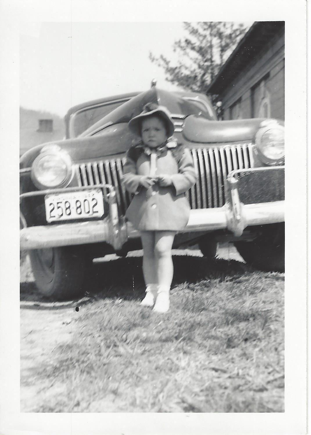 Toddler Neva by the family car