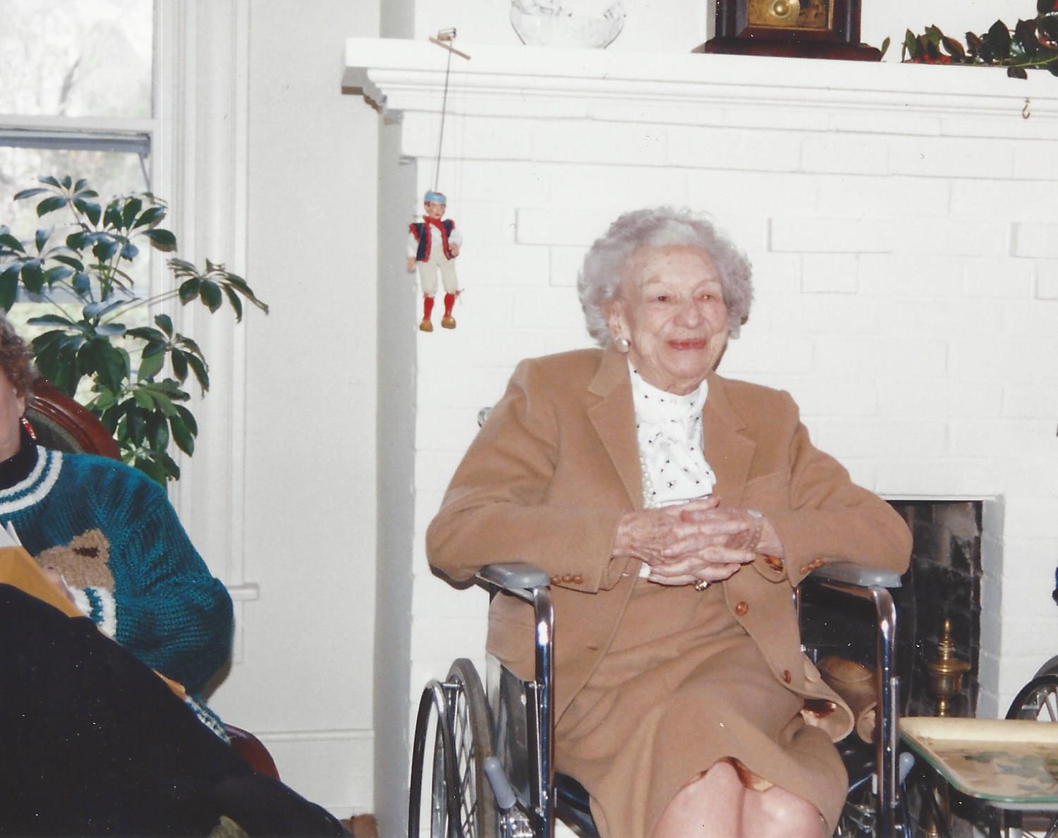 Virge smiling by the fireplace in later years