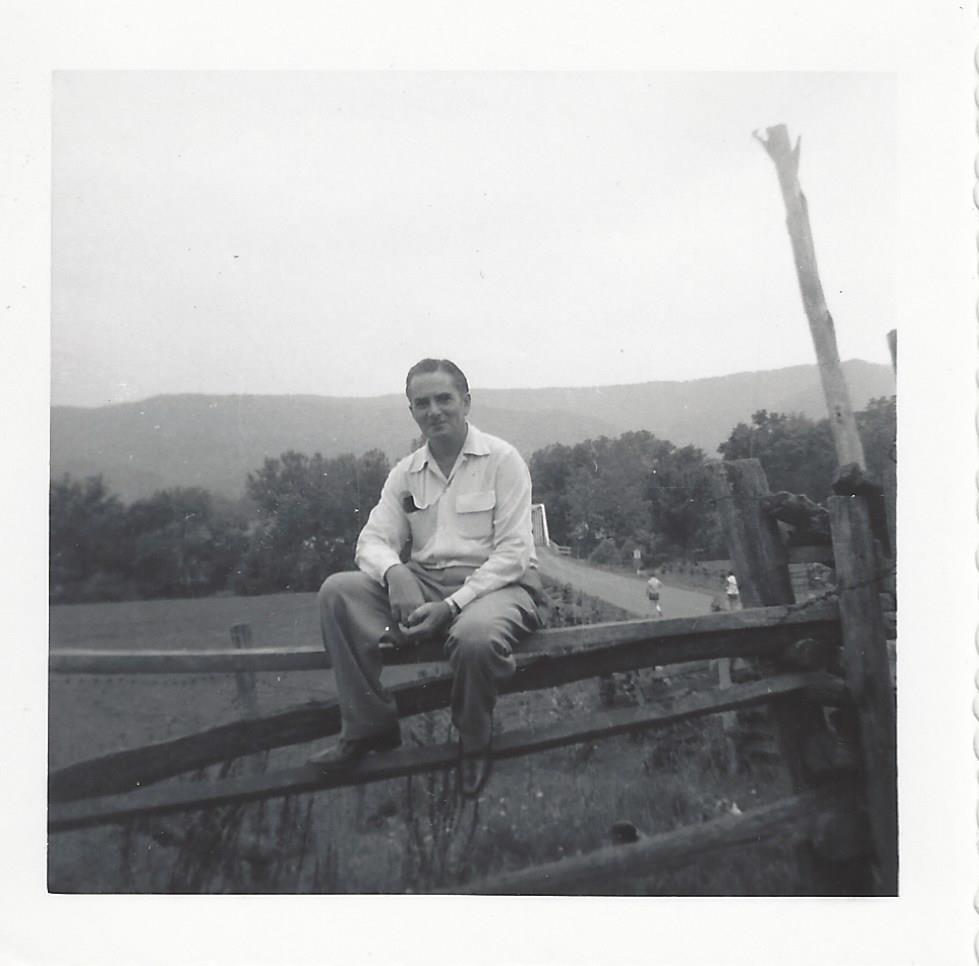 Doc Campbell on a fence in the mountains