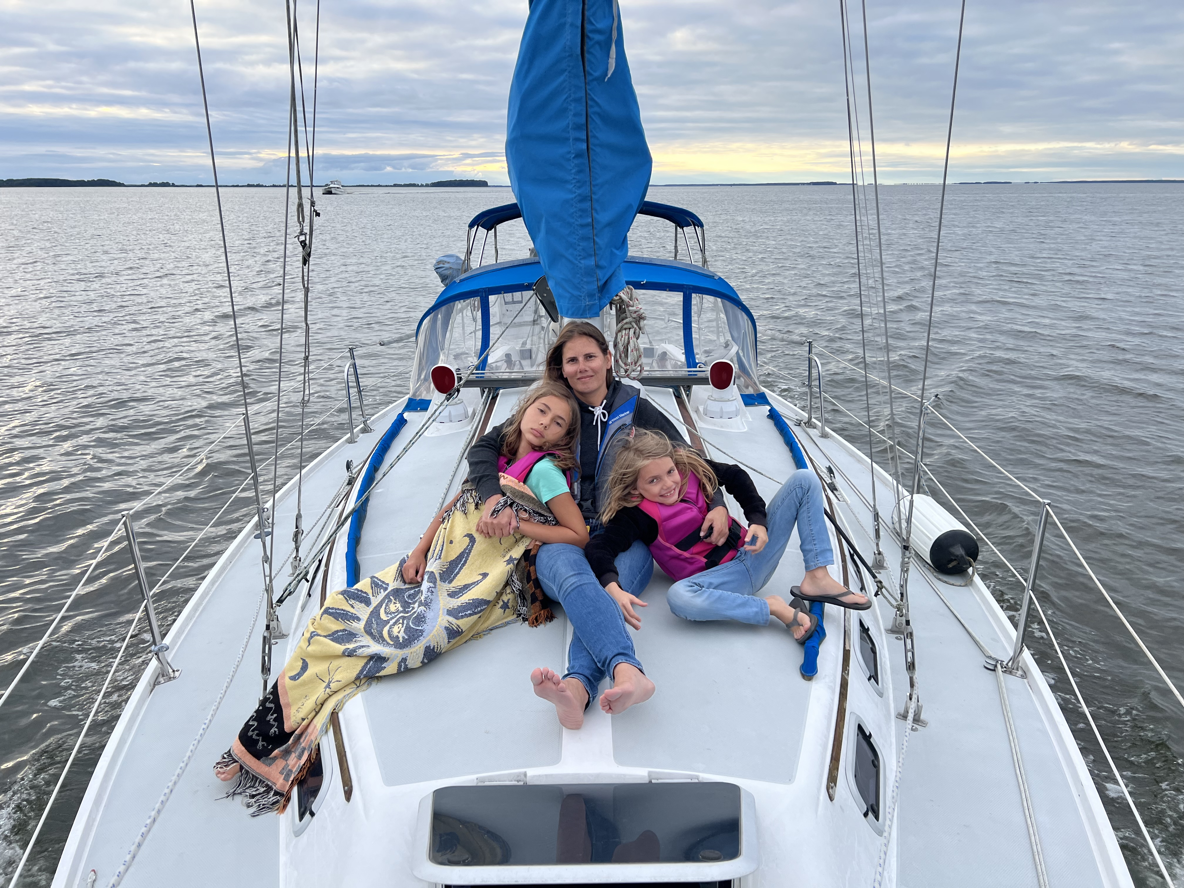 Evelyn, Ollie and Hanna on the foredeck of Seventh Heaven at sunset