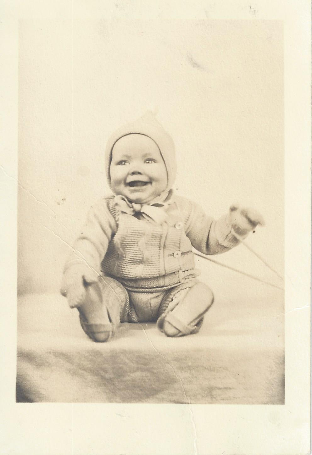 Unknown laughing baby in bonnet